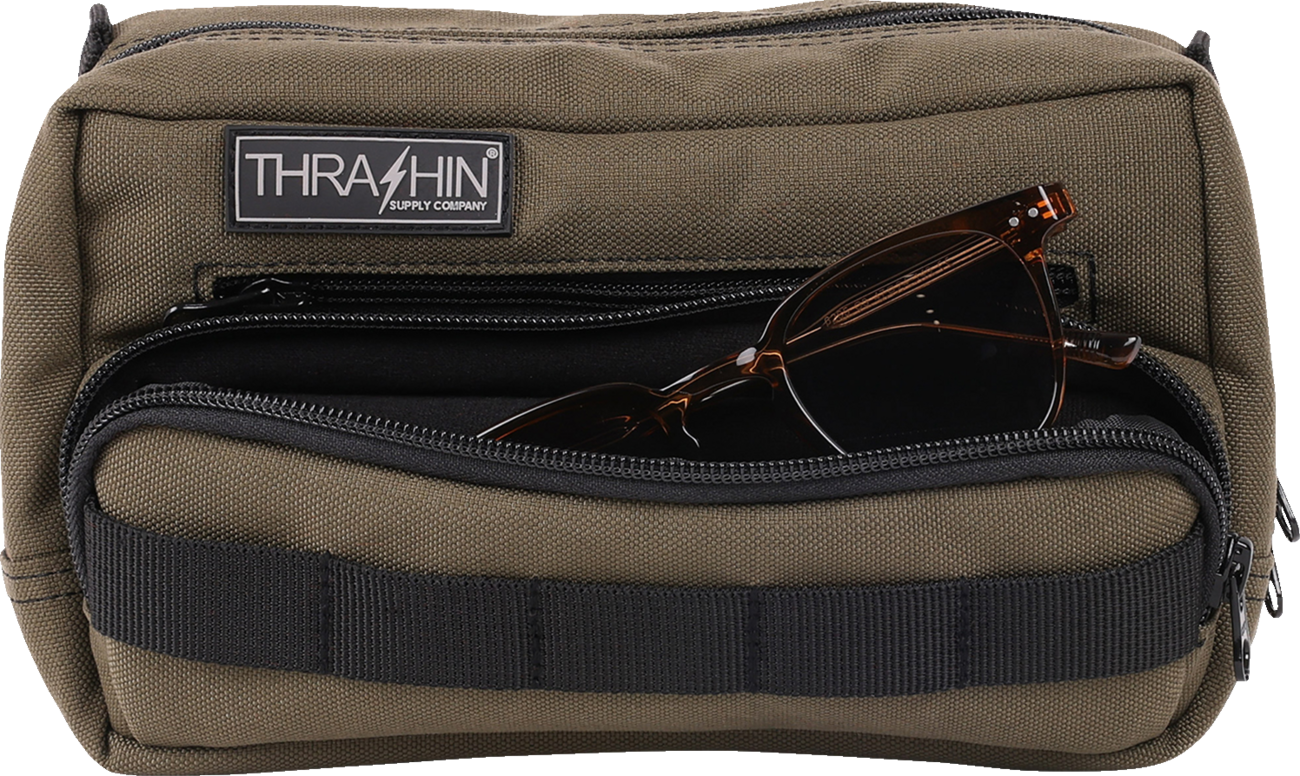 Green THRASHIN SUPPLY CO. Handlebar Bag Plus mounted on a bicycle handlebar, made of durable material with secure straps.