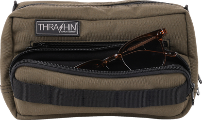 Green THRASHIN SUPPLY CO. Handlebar Bag Plus mounted on a bicycle handlebar, made of durable material with secure straps.