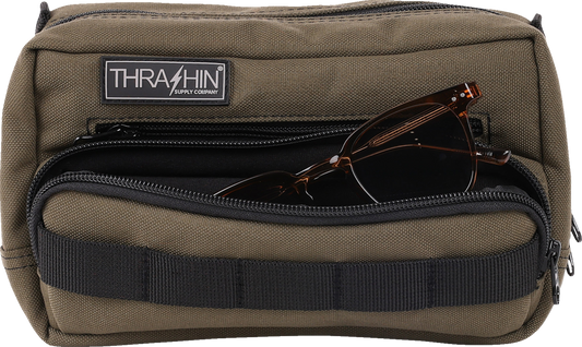 Green THRASHIN SUPPLY CO. Handlebar Bag Plus mounted on a bicycle handlebar, made of durable material with secure straps.