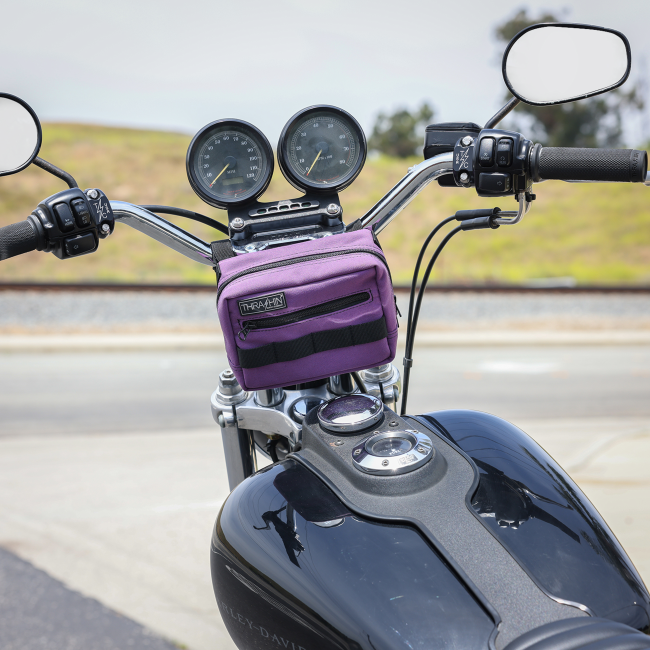 Purple handlebar bag by THRASHIN SUPPLY CO. with adjustable straps and compact storage for cycling accessories.