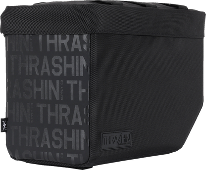 Black leather motorcycle saddlebags with silver buckles, THRASHIN SUPPLY CO. Essential Saddlebags 10L TSB-0020 attached to a motorcycle.