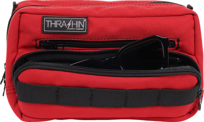 Red Thrashin Supply Co. Handlebar Bag Plus mounted on a bicycle handlebar, featuring durable straps and compact design.
