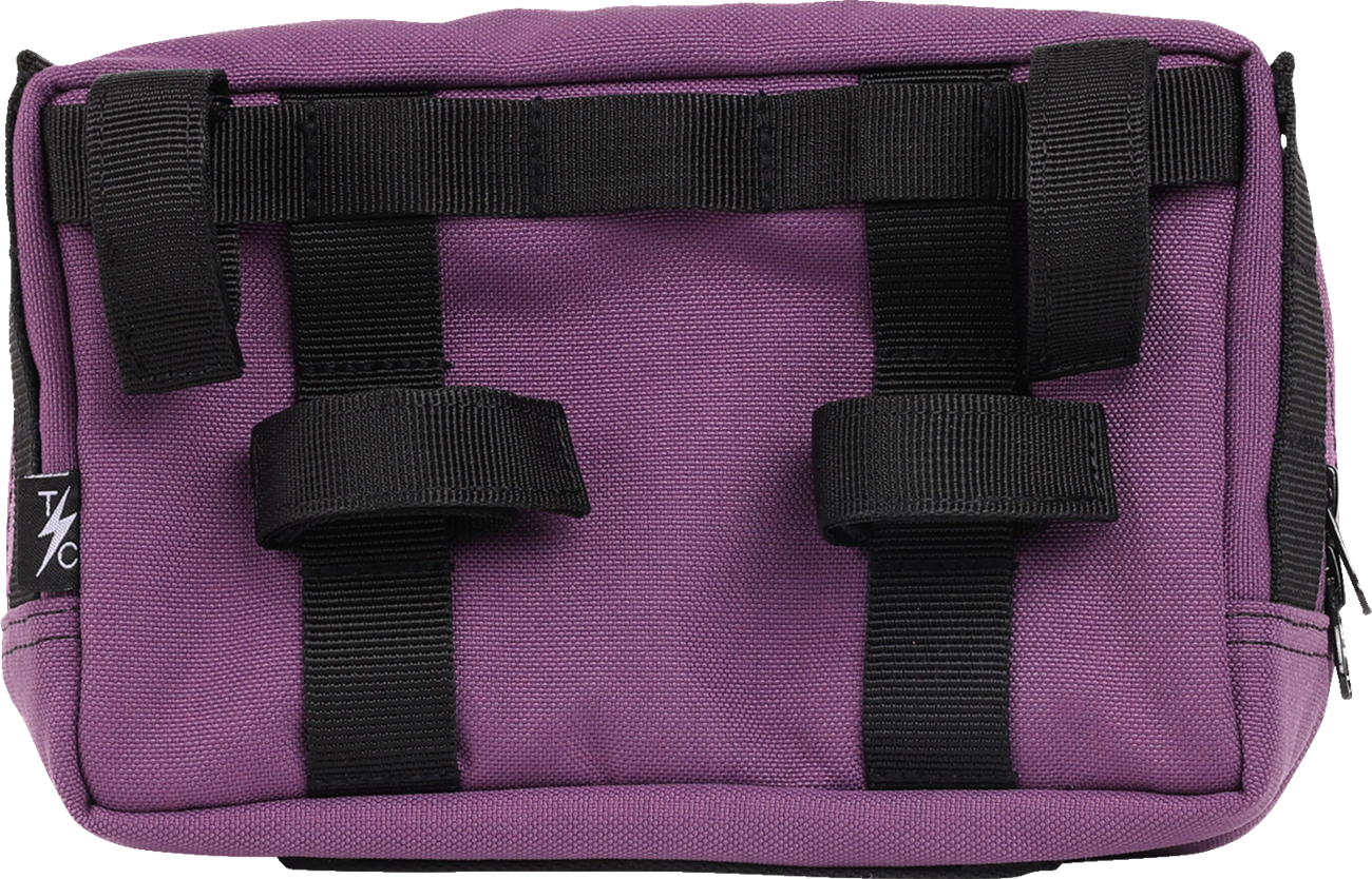Purple THRASHIN SUPPLY CO. Handlebar Bag Plus mounted on a bicycle handlebar, with adjustable straps and compact design.