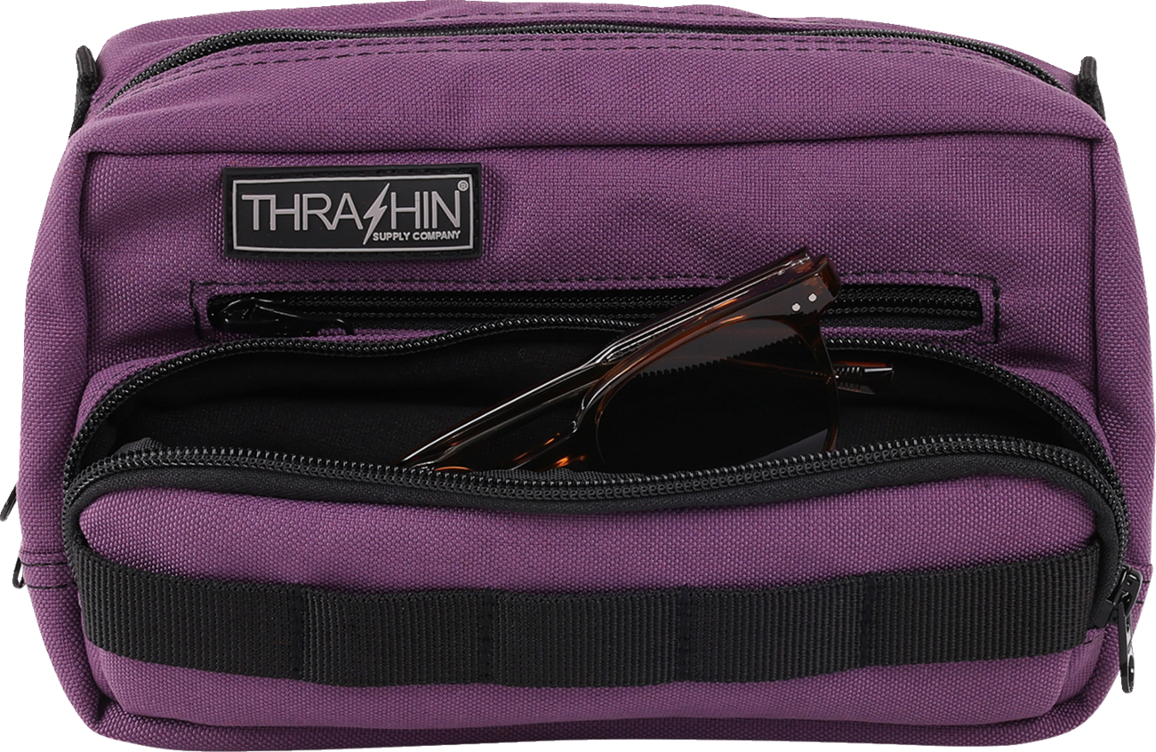 Purple THRASHIN SUPPLY CO. Handlebar Bag Plus mounted on a bicycle handlebar, showing its compact design and secure attachment.