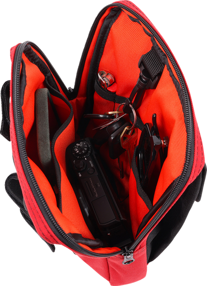 Red THRASHIN SUPPLY CO. Handlebar Bag Slim mounted on a bicycle handlebar, showcasing its compact design and vibrant color.