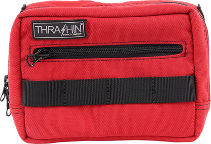 Red THRASHIN SUPPLY CO. handlebar bag with adjustable straps and compact design for bike storage.