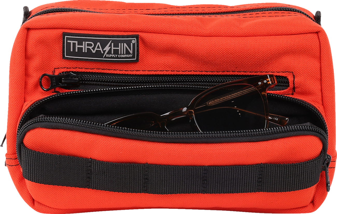 Orange handlebar bag by THRASHIN SUPPLY CO., featuring durable straps and compact design for bike storage.