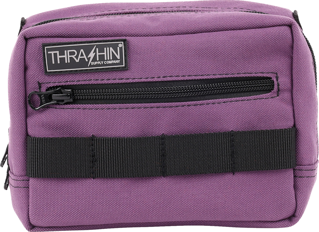 Purple handlebar bag from THRASHIN SUPPLY CO. with adjustable straps and compact design, mounted on a bicycle handlebar.