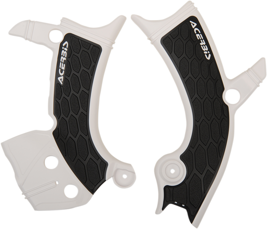 Acerbis X-Grip white and black motorcycle frame guards installed on a bike's body, providing protection and style.
