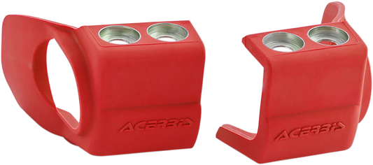 Acerbis red shoe protectors for inverted motorcycle forks, designed to shield forks from dirt and damage, shown on a motorcycle suspension.