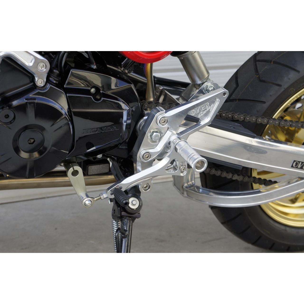 Over Racing 4-position rearsets for Honda Grom motorcycle, featuring metallic footpeg and adjustable mounting points.