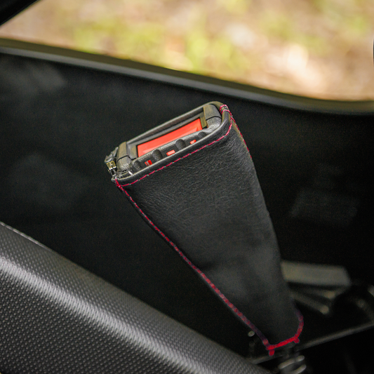 Black SHOW CHROME seat belt covers with red stitching for engine safety, designed by Bill's Exhausts.