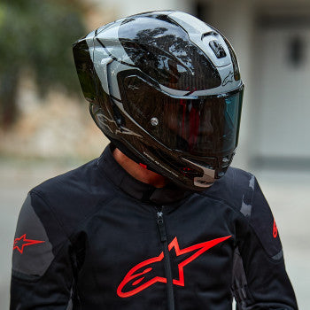 Alpinestars Supertech R10 helmet in carbon, silver, and black with ventilation vents and aerodynamic design, medium size.