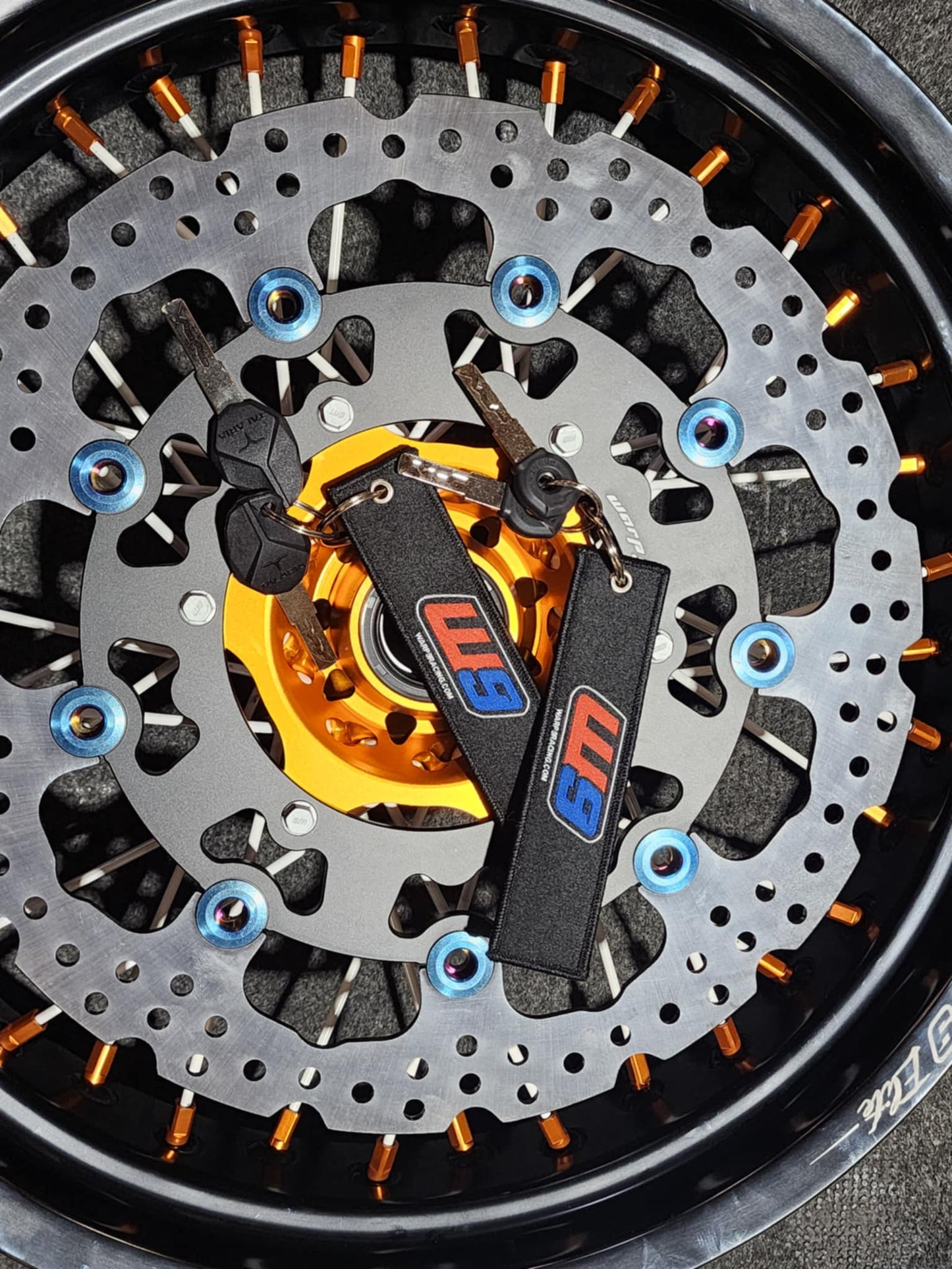 Warp9Racing fabric key chain featuring the Warp 9 Racing logo and vibrant design, attached to a metal keyring.