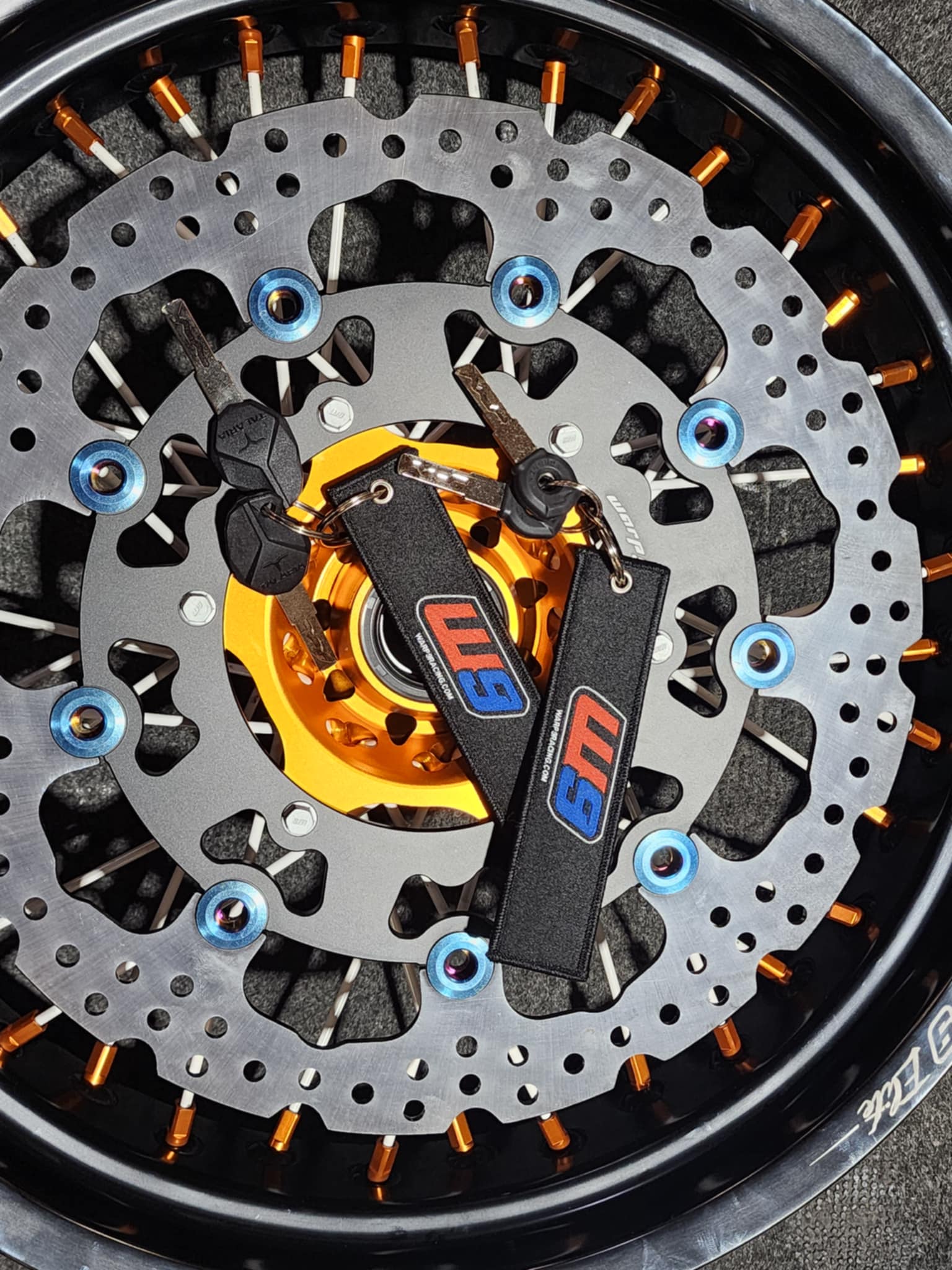 Warp9Racing fabric key chain featuring the Warp 9 Racing logo and vibrant design, attached to a metal keyring.