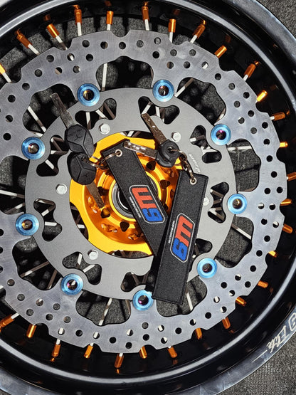 Warp9Racing fabric key chain featuring the Warp 9 Racing logo and vibrant design, attached to a metal keyring.