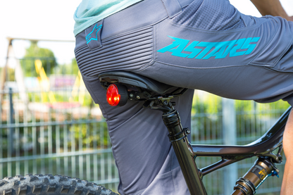 Bill's Exhausts SP CONNECT All-Round LED Safety Light in red, showing 100 lumens, attached to a phone for visibility and safety.