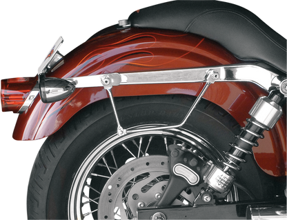 SADDLEMEN Drifter Rigid Slant Saddlebag on motorcycle seat, black leather with metal hardware, designed for rugged touring rides.