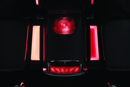 Kuryakyn Tracer LED inserts for saddlebag supports in black mounted on motorcycle supports, showcasing sleek LED lighting design.