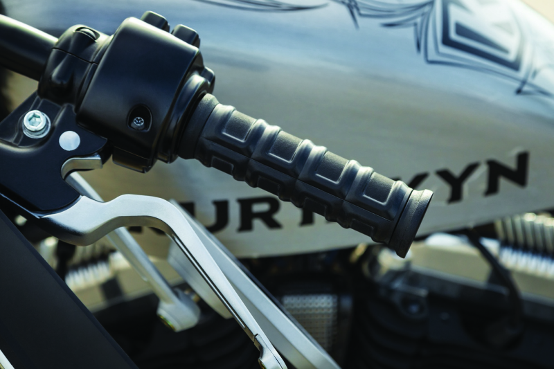 Kuryakyn Dillinger grips with dual cables in satin black for motorcycle handlebars, featuring textured design and chrome accents.