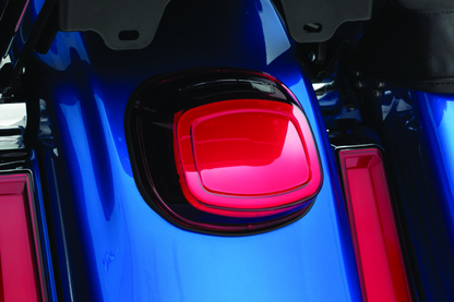 Kuryakyn Tracer LED taillight with red lens and license plate light for Harley Davidson motorcycle.