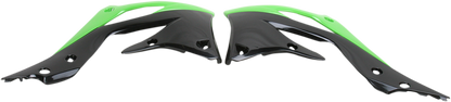 A set of ACERBIS radiator shrouds in green and black for motorcycle body protection, featuring aerodynamic design and branding.