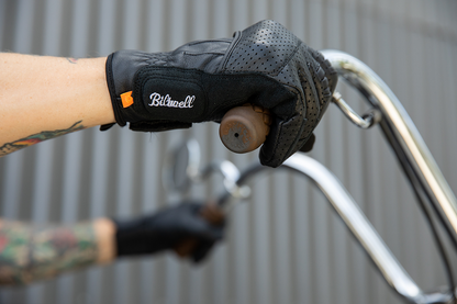 Black BILTWELL Borrego gloves in large size, showing textured leather exterior and secure wrist strap for motorcycle riding comfort.