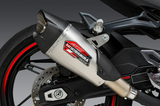 YOSHIMURA AT2 slip-on exhaust with matte carbon fiber end cap, featuring sleek metal finish and compact design.