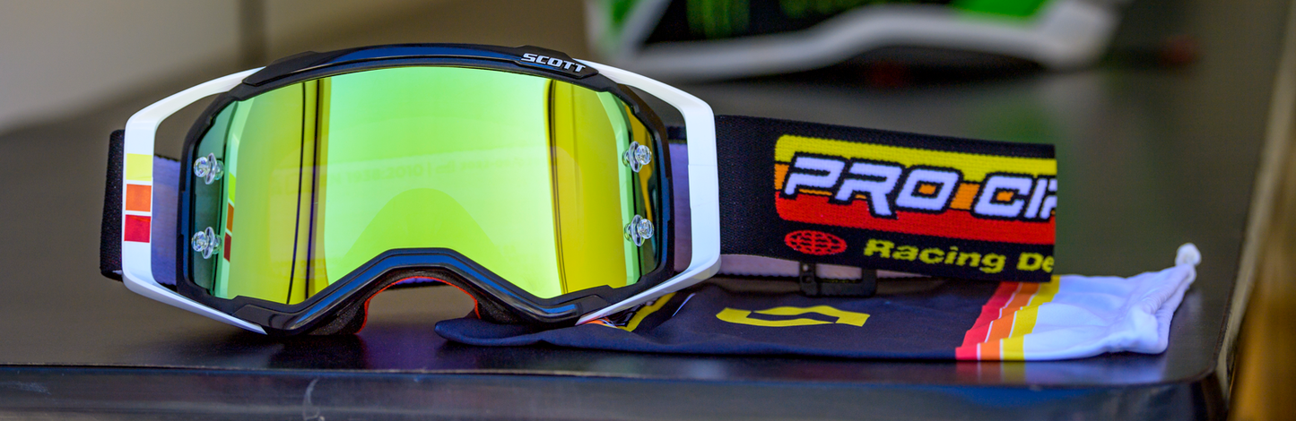 Scott Pro Circuit Prospect goggles in black and white with yellow accents, featuring clear lenses and adjustable straps.