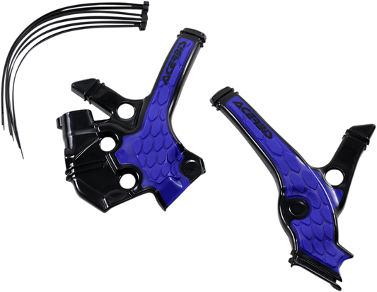 A close-up of ACERBIS X-Grip black and blue frame guards on a Yamaha YZ85 motorcycle body, showing textured protective design.