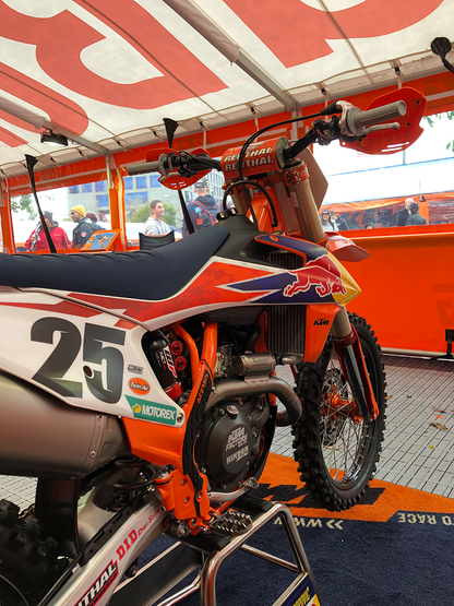 A close-up of Acerbis X-Grip frame guards in orange and black for motorcycle body protection, designed for durable fit.