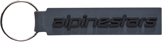 Alpinestars linear key fob with protective gear design, featuring black and gray accents, attached to a keychain.