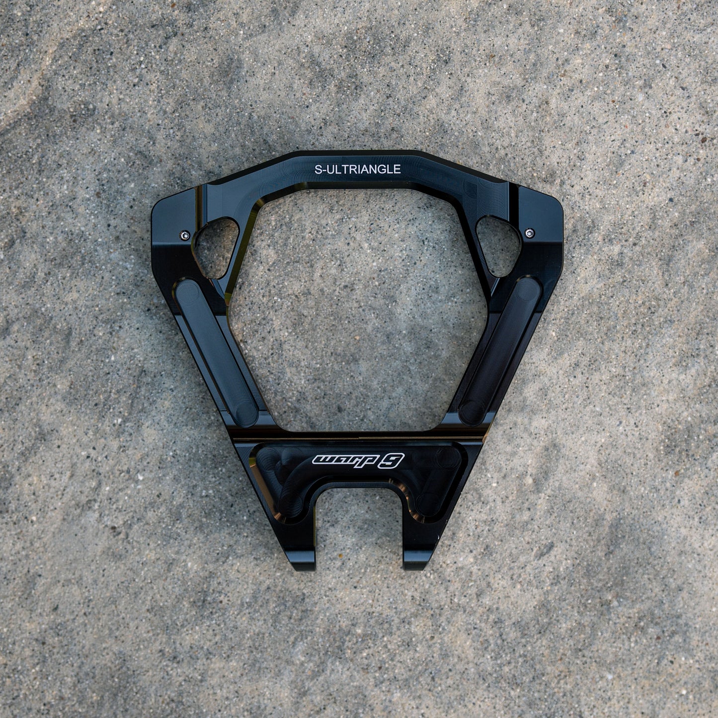 Close-up of Warp9Racing Surron Ultra Bee Triangles for electric bike modification, showing detailed metal components and mounting points.