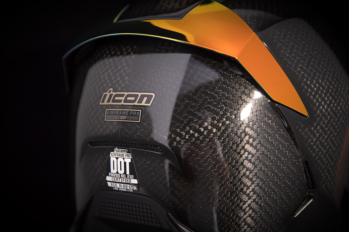 ICON Airframe Pro™ helmet in red with carbon fiber shell, showing a close-up of the helmet's aerodynamic design and branding.