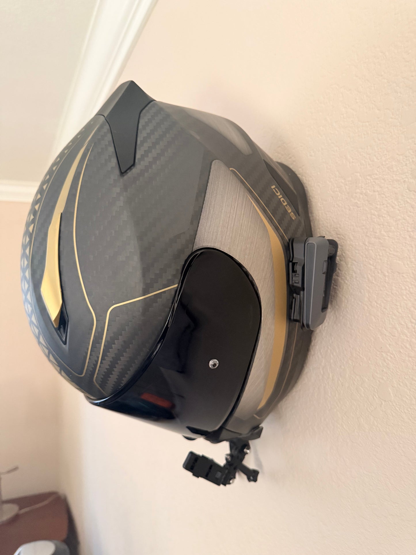Slim-Flush motorcycle helmet wall mount by McCoy Industries, securely holding a helmet on a wall with a sleek design.