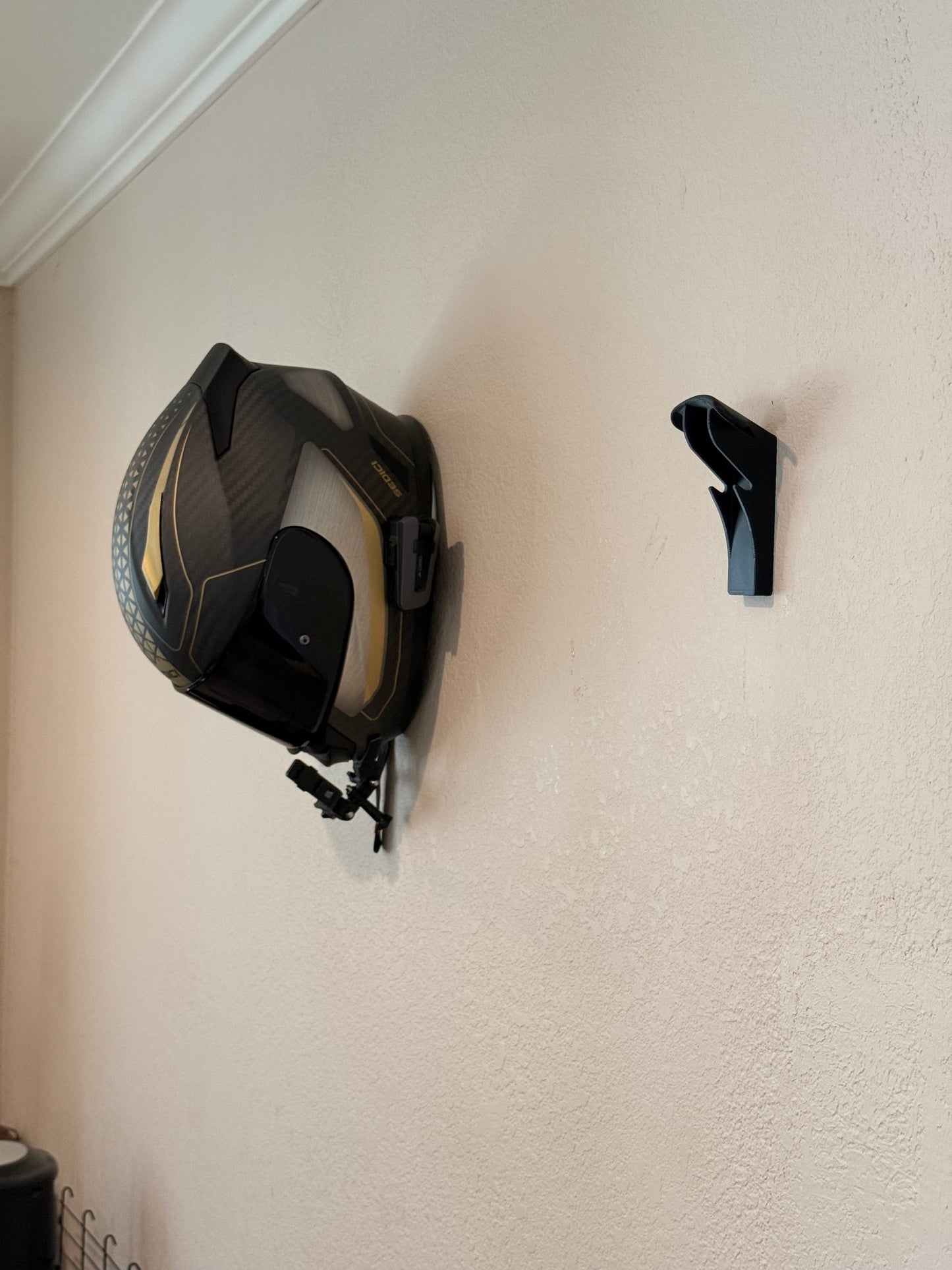 Slim-Flush motorcycle helmet wall mount by McCoy Industries mounted on wall, designed to securely hold a motorcycle helmet.