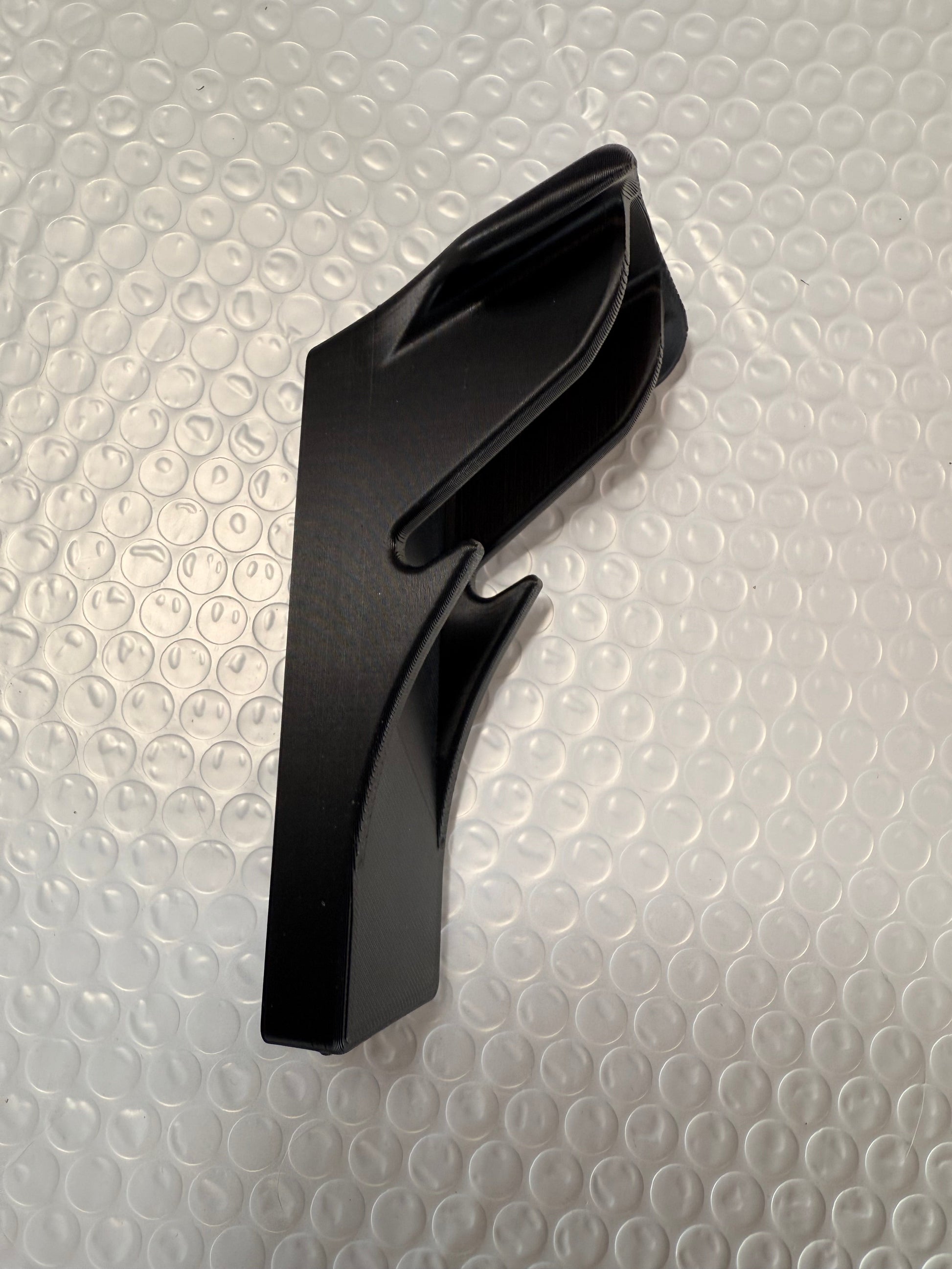 Slim-flush motorcycle helmet wall mount by McCoy Industries, shown holding a helmet on a wall for secure storage and display.