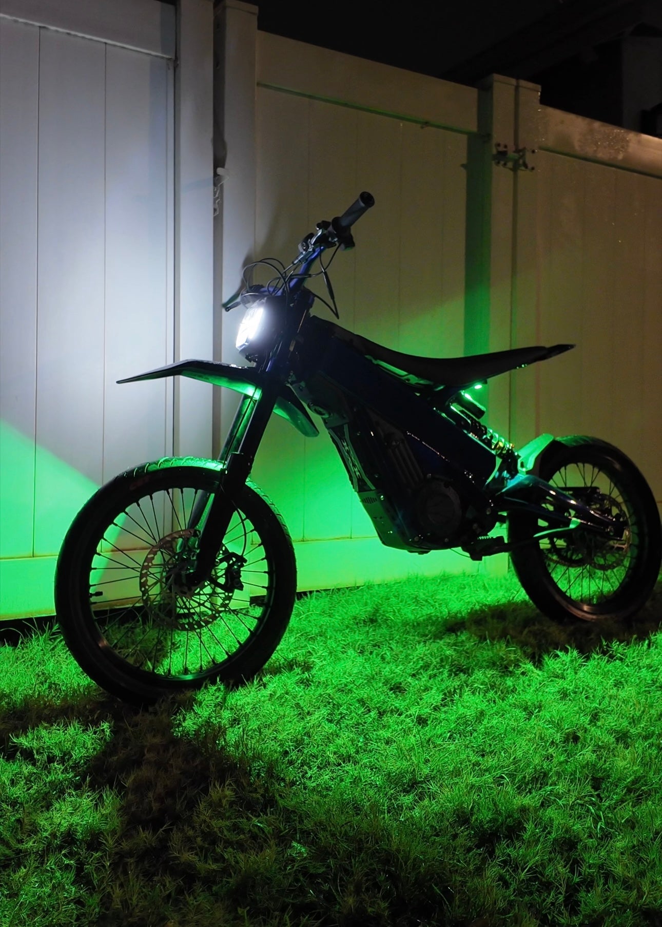 Project9 Hyperglow Surron Ultra Bee under glow kit installed on front and rear of Surron electric bike, showcasing vibrant lighting.