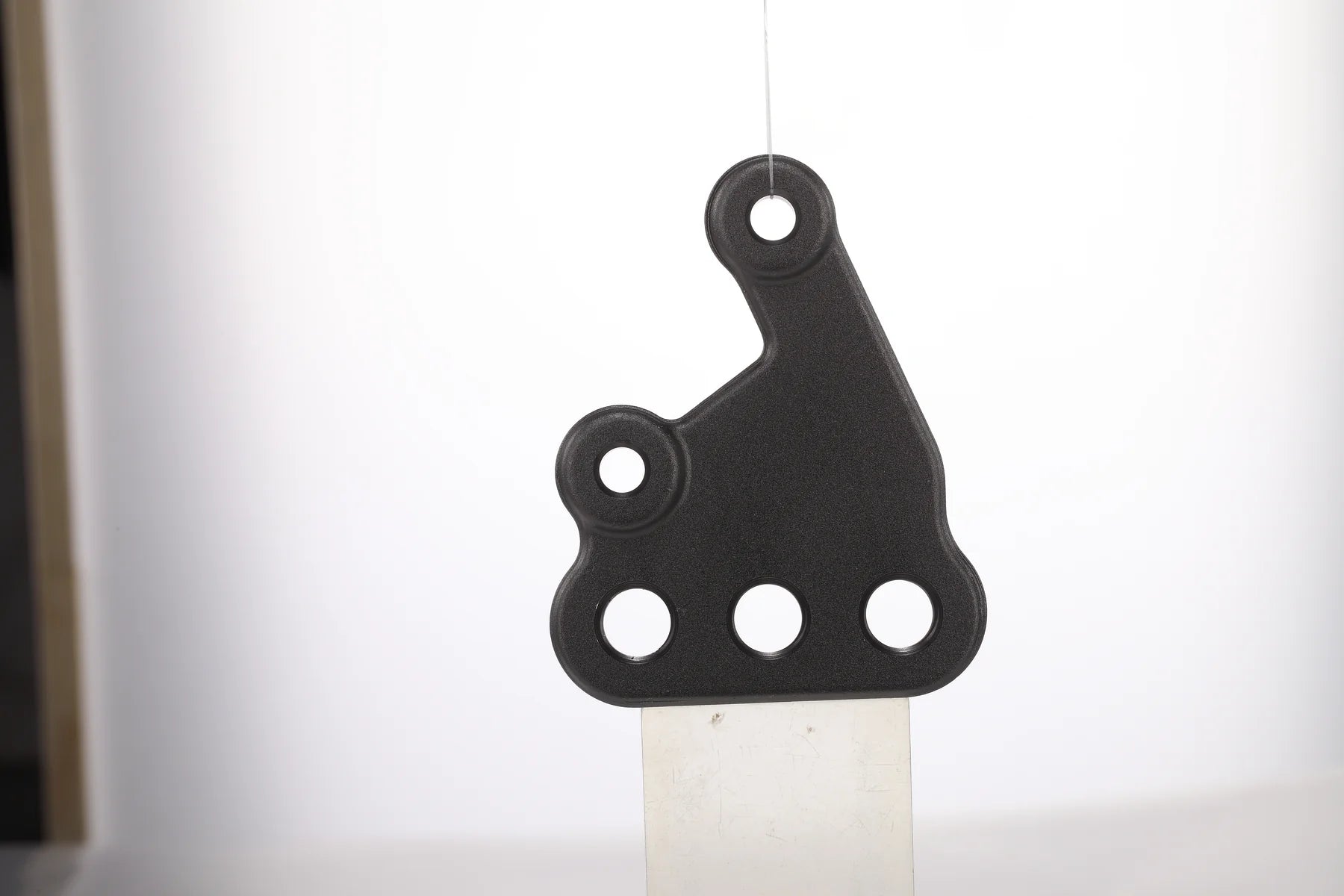 E Ride Pro left footpeg mounting bracket assembly for motorcycle, showing the sturdy metal bracket with mounting points.