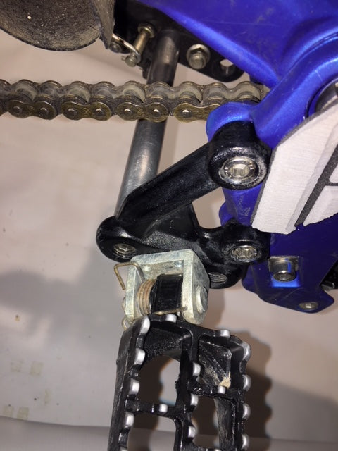 eDirtyBike Sur-Ron LBX foot peg support brace attached to the bike's foot peg for added stability and protection.
