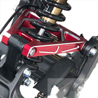 Red aluminum suspension triangle on a Surron Light Bee LBX electric bike, showcasing the eDirtyBike suspension component.