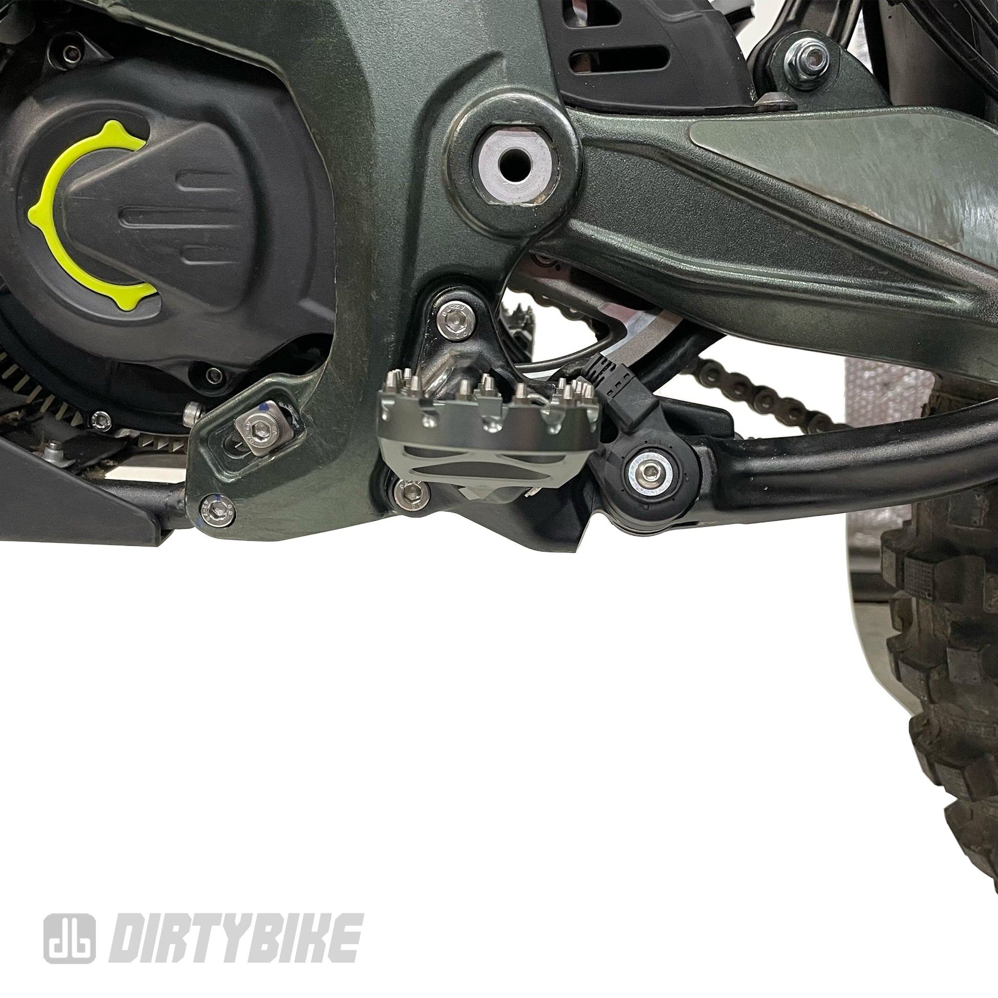 Aluminum CNC heavy-duty foot peg on a Sur-Ron Ultra Bee electric bike, showing textured surface and mounting hardware.