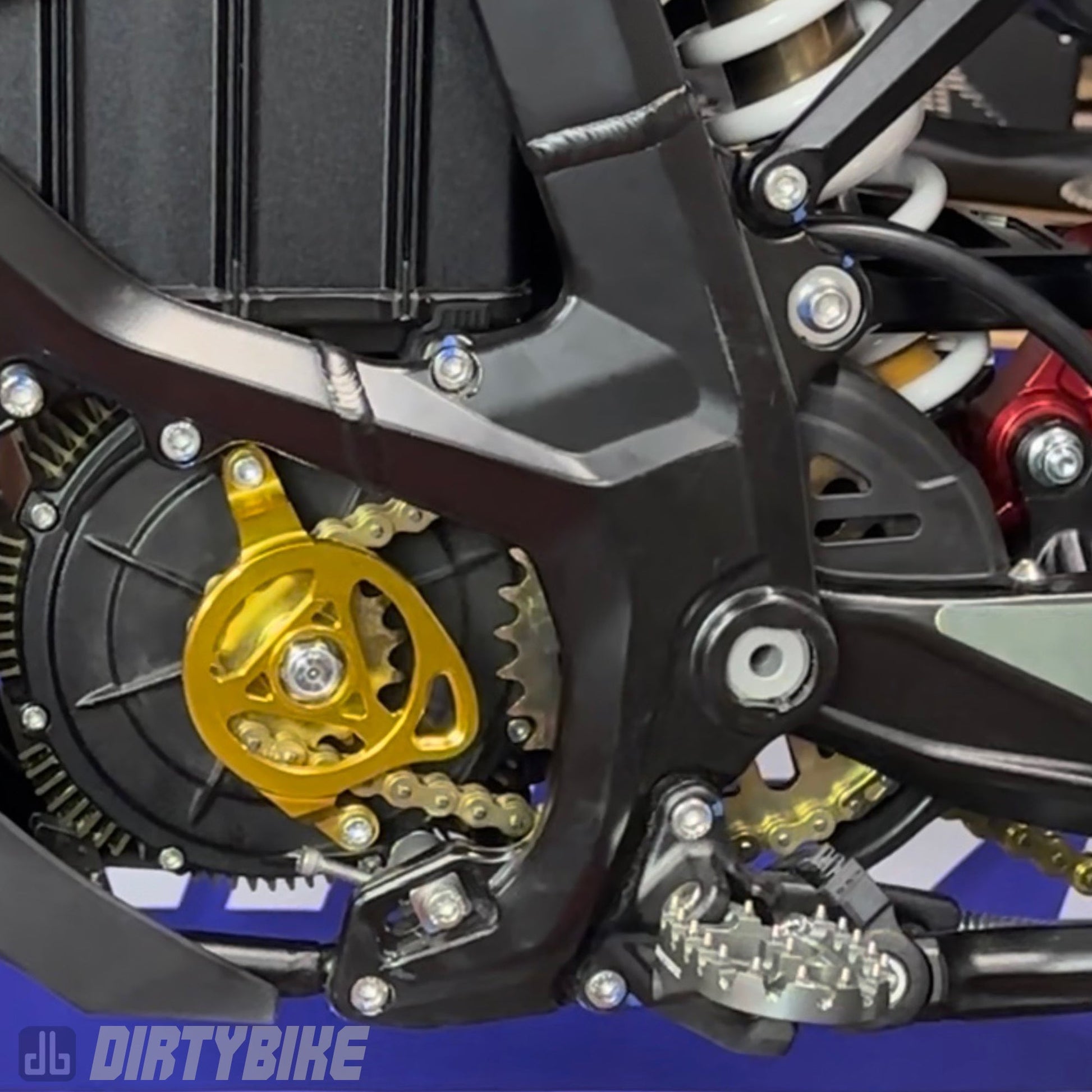 Aluminum CNC motor sprocket cover on Surron UltraBee e-bike, featuring precise machining and durable construction.