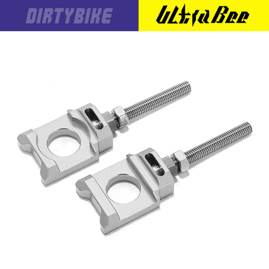 Silver aluminum axle blocks for Surron Ultra Bee eBike, designed by eDirtyBike, shown attached to the bike's axle.