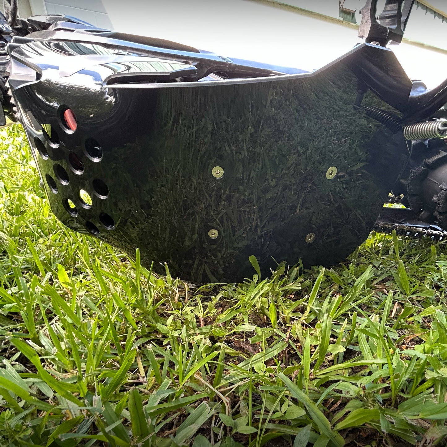Surron Ultra Bee eDirtyBike skid plate mounted on bike frame, providing protection for off-road electric motorcycle.