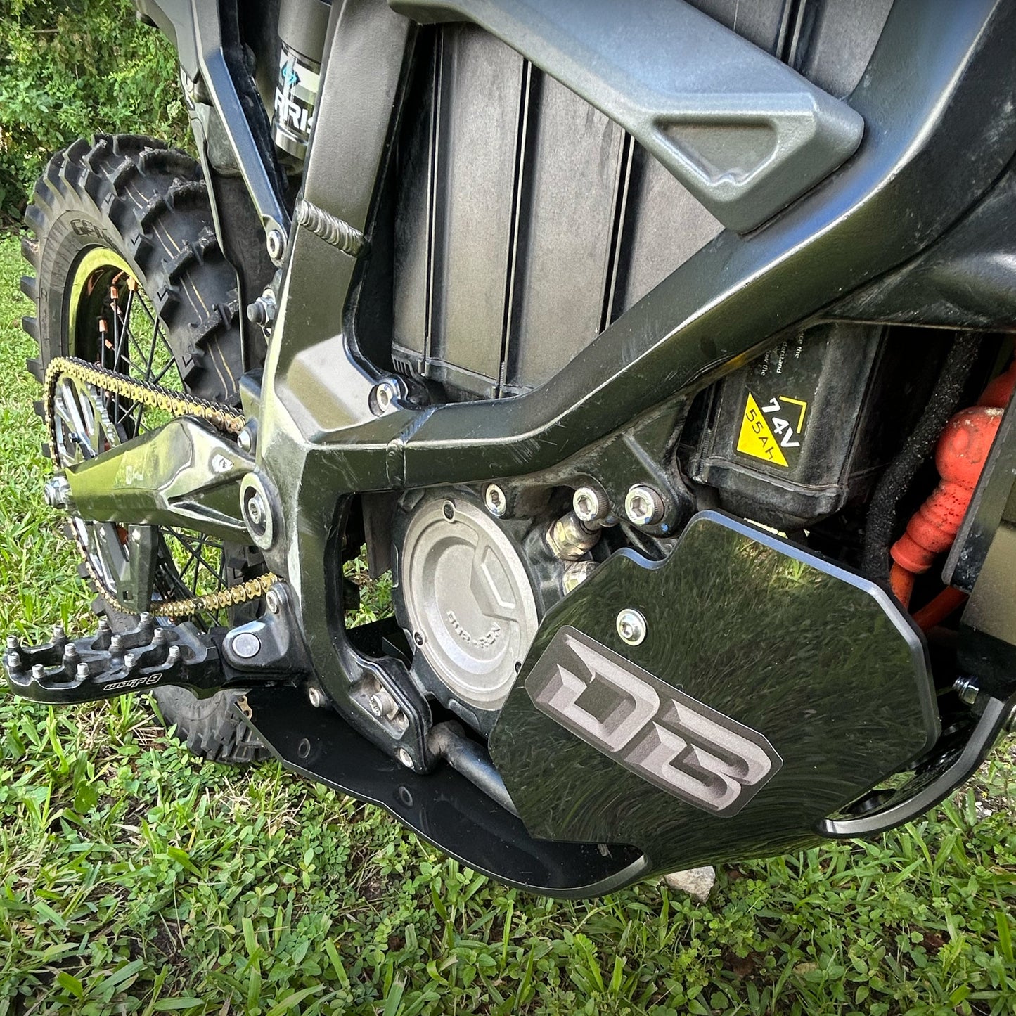 eDirtyBike skid plate installed on Surron Ultra Bee electric bike, showing durable protective metal underframe detail.
