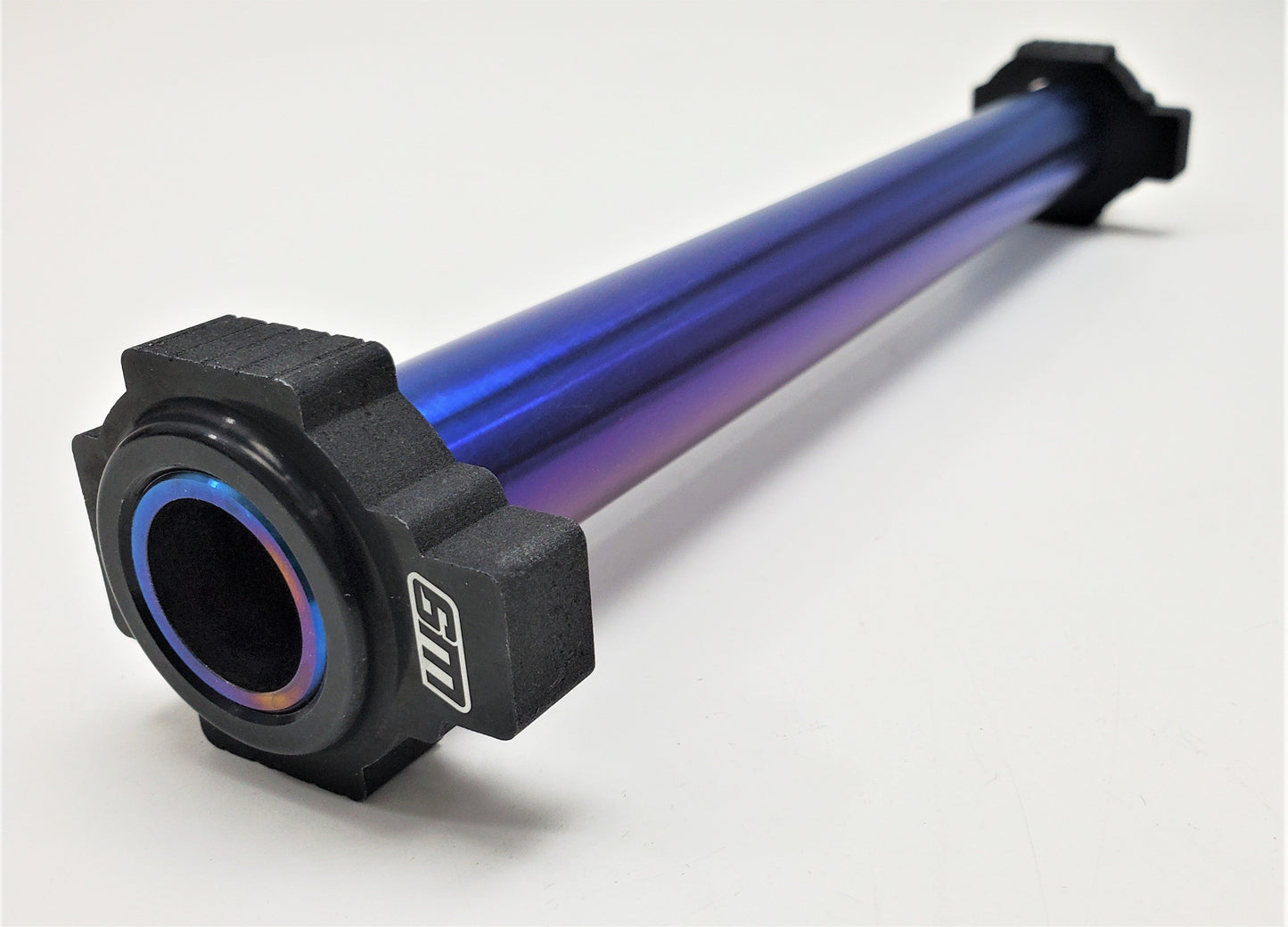 Warp9Racing titanium rear axle for KTM motorcycles, showcasing a durable, lightweight metal component with a polished finish.