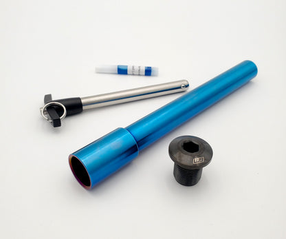 Warp9Racing titanium front axle for bicycles, showcasing a sleek, lightweight metal axle with detailed machining and branding.