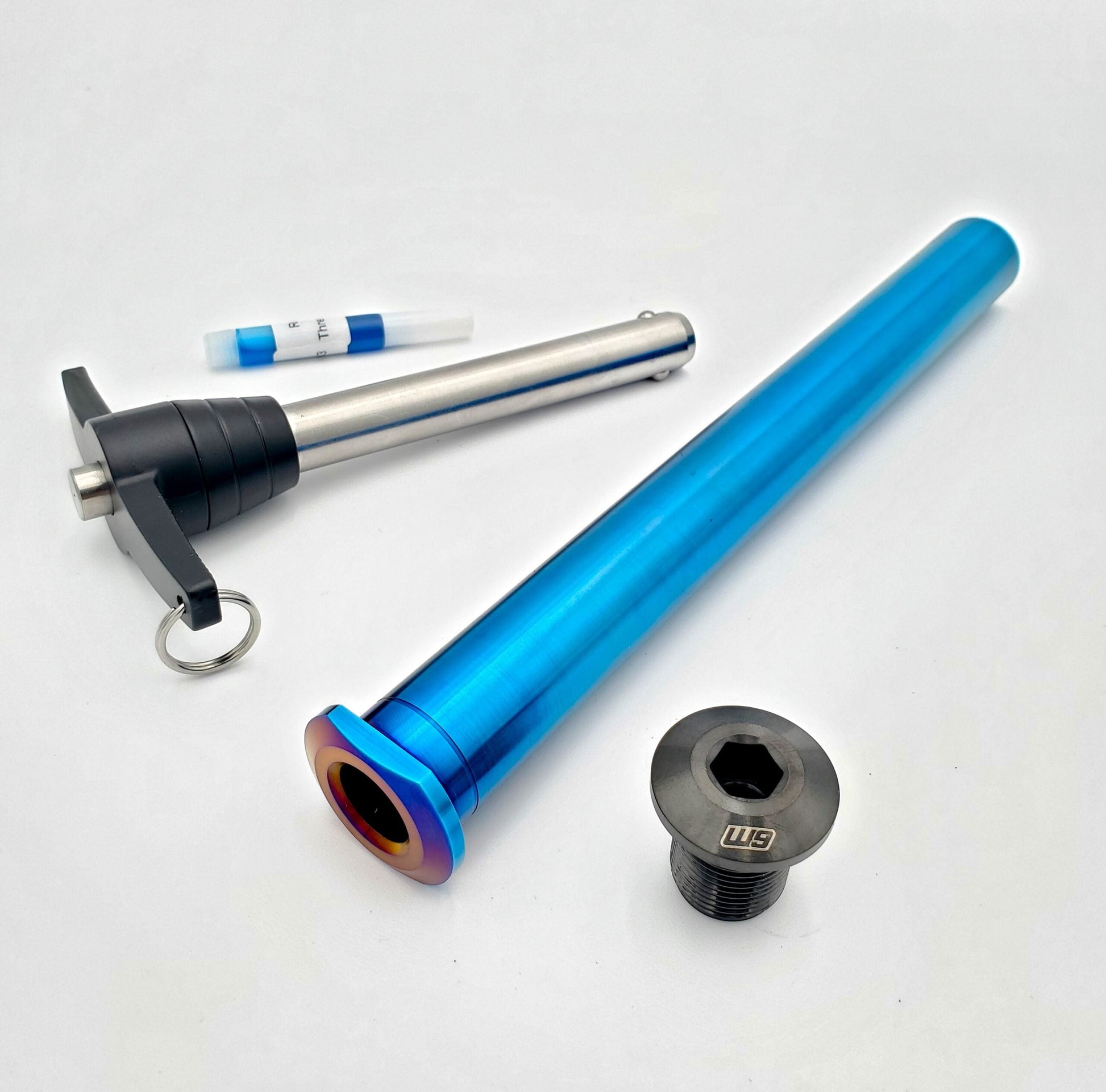 Titanium rear axle for Husqvarna motorcycle by Warp9Racing, showing a sleek, lightweight, precision-engineered component.