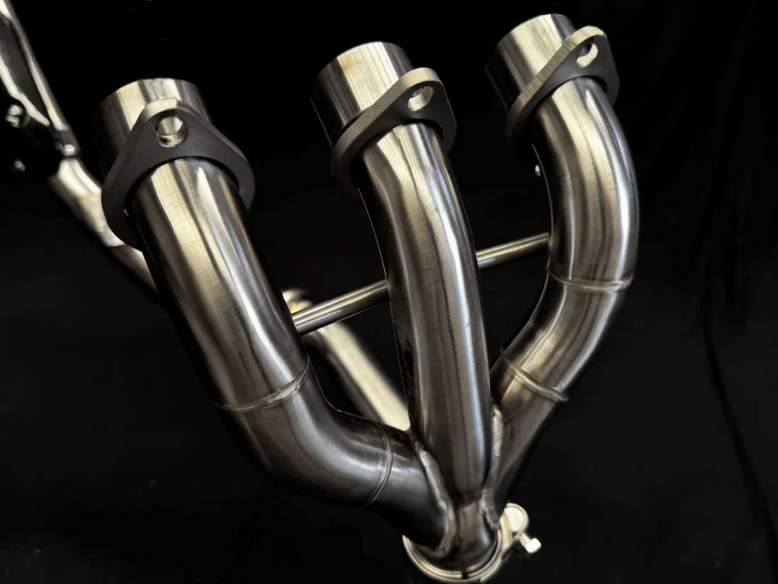 Stainless steel headers for Triumph Tiger 850-900 full exhaust system by Bill's Exhausts, showing polished metal pipes and fittings.